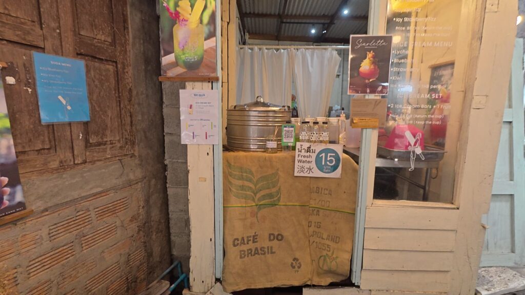 コーヒー麻袋とアイスクリームメニューが置かれたカフェの店先