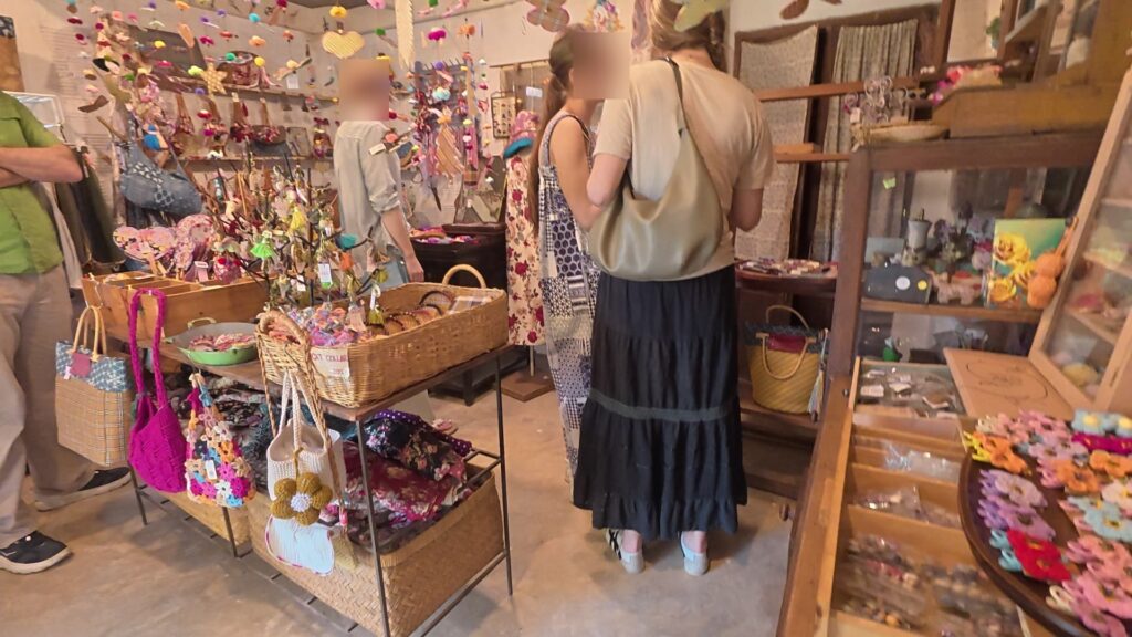 カラフルな手作り雑貨が並ぶ店内で商品を選ぶ人