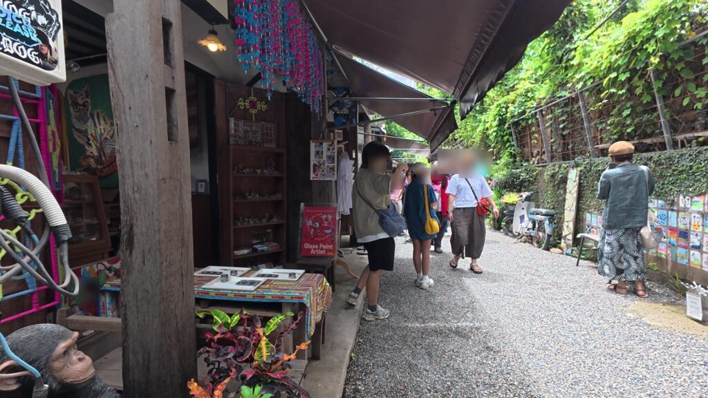 Glass Paint Artistの看板が出た通りを歩く観光客