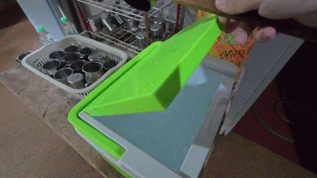 クーラーボックスから柄杓を取り出す手元
