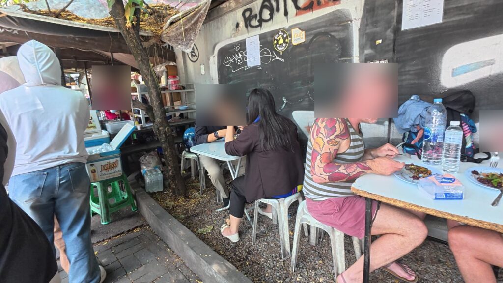 グラフィティの壁沿いの客席、複数人が食事中