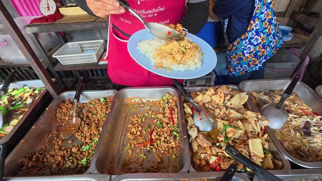 店員がご飯におかずを盛り付ける様子