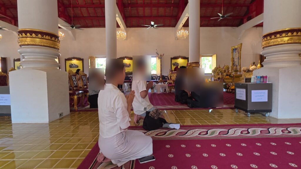 祭壇前で正座して祈る参拝客