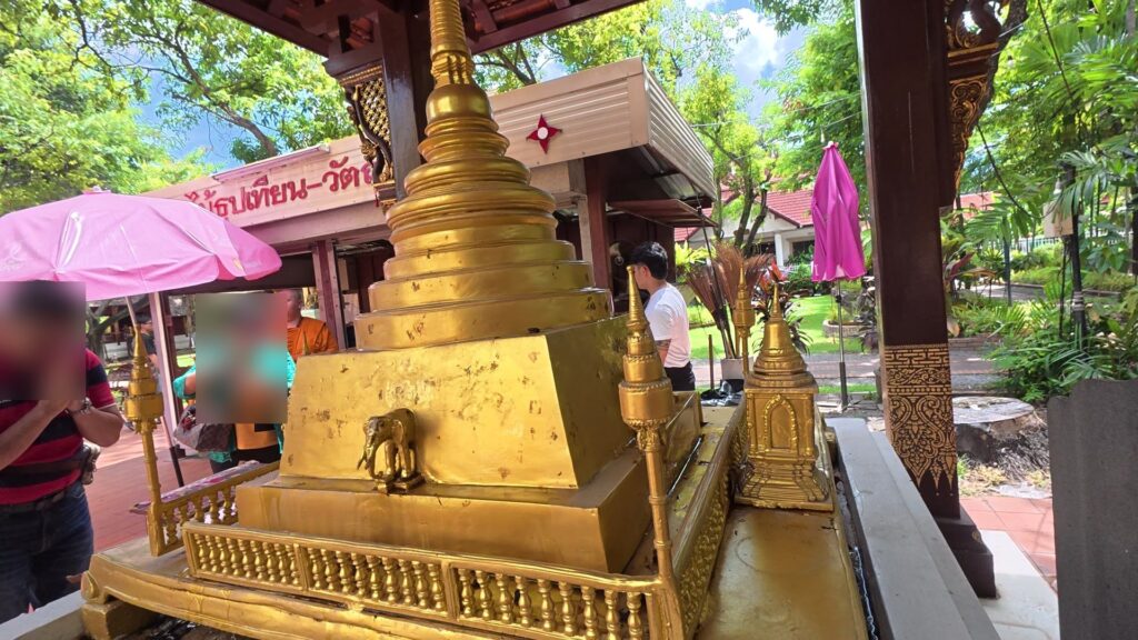 小さな仏塔の前で祈る参拝客