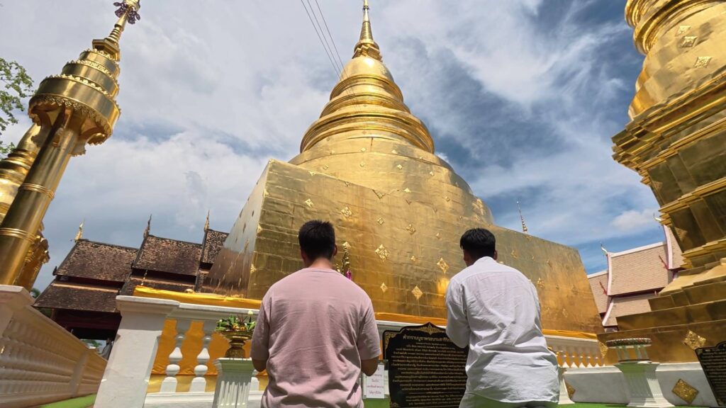 仏塔に向かって祈る参拝客の後ろ姿